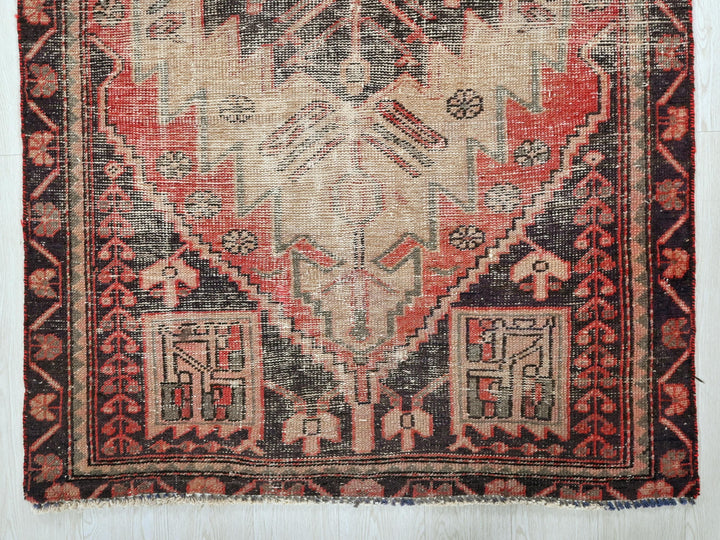 a red and black oriental rug on a white wall