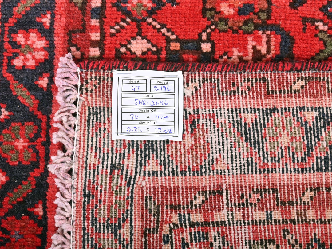 a pile of red and black rugs with a price tag