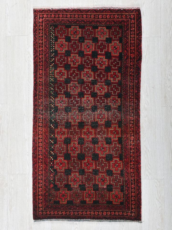 a red and black rug on a white floor