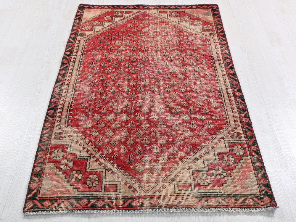 a red and black oriental rug on a white floor