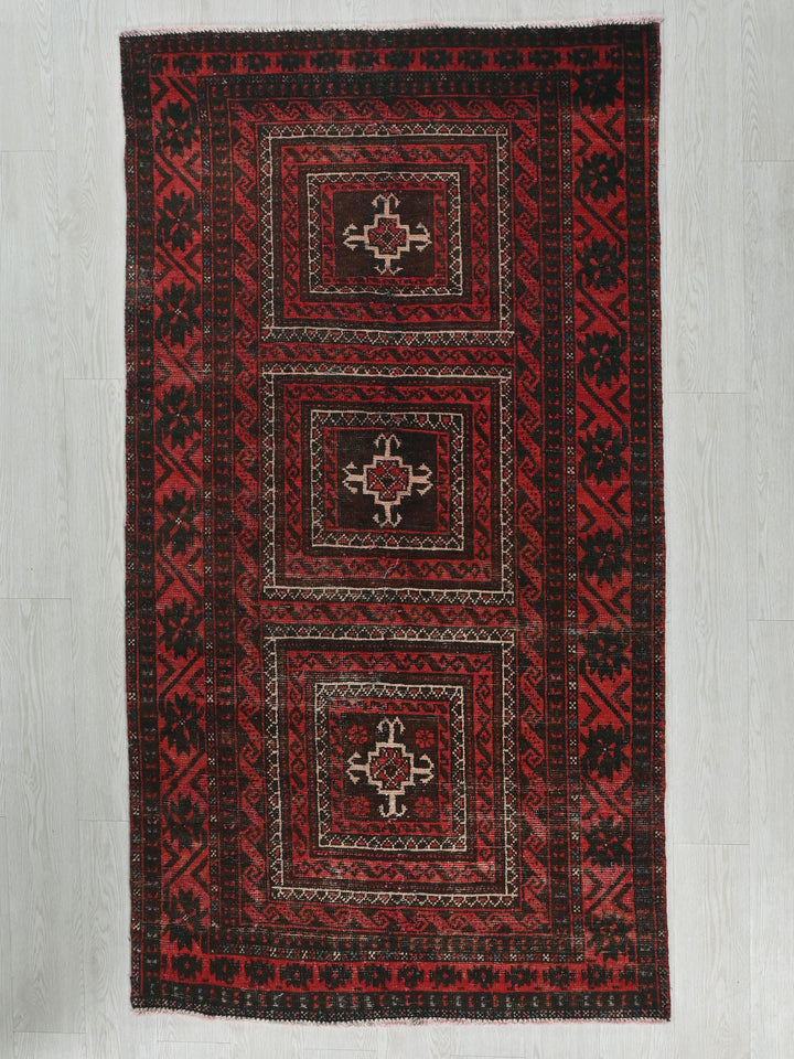 a red and black rug on a white floor