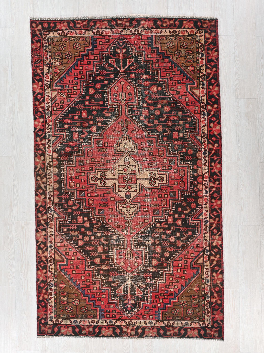 a red and black rug on a white floor