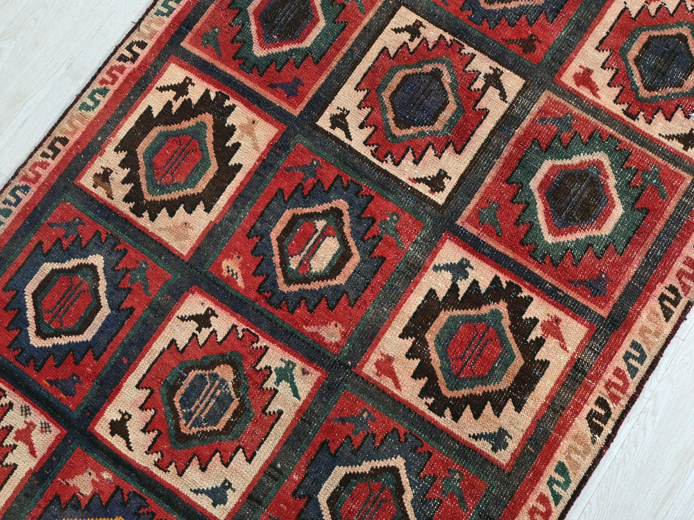 a red and black rug on a white floor