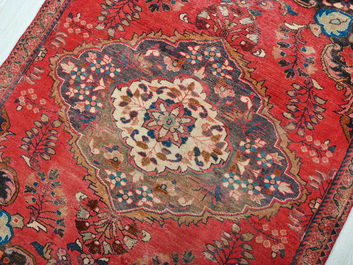 a red rug with a floral design on it