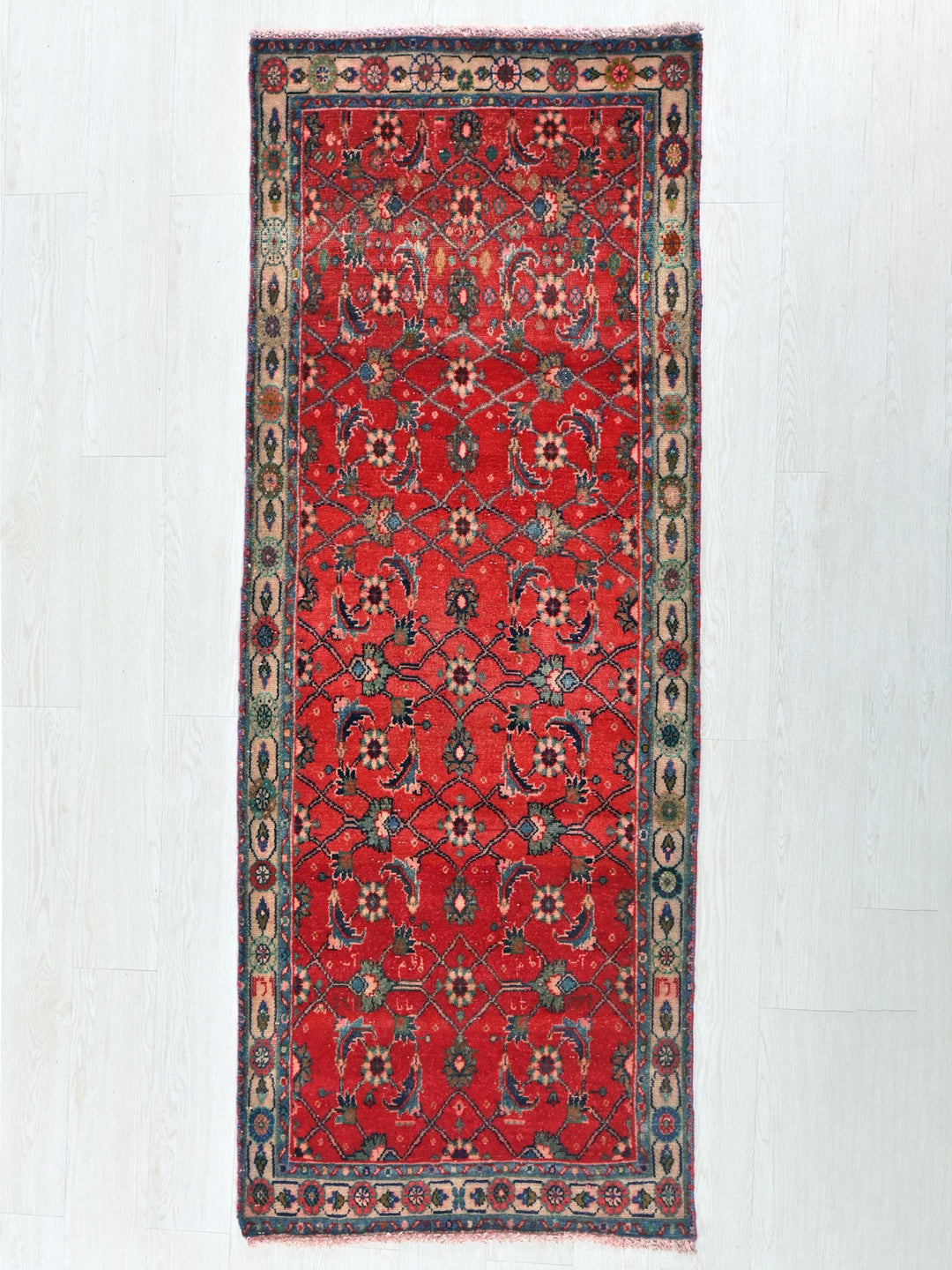 a red rug with a floral design on a white background