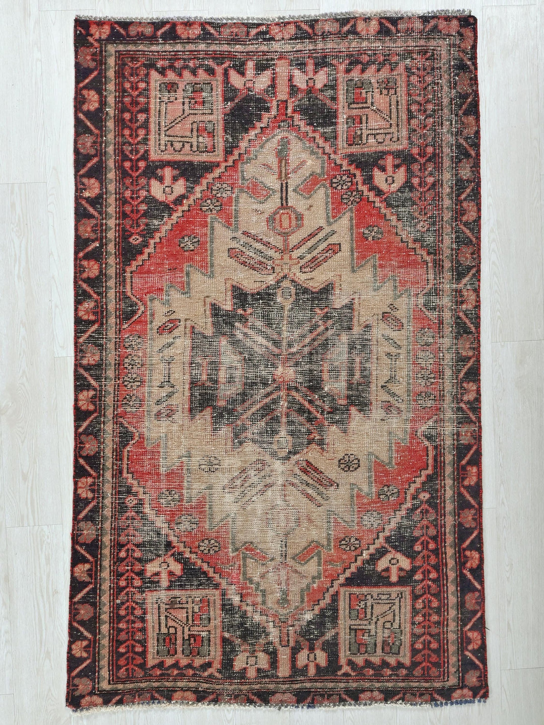 a red and black rug with a design on it