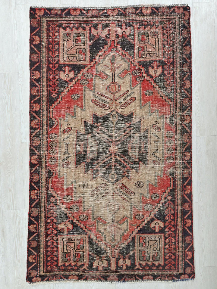 a red and black rug with a design on it