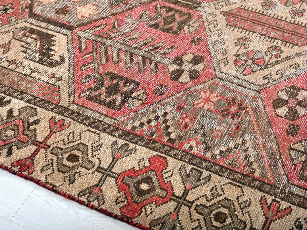 a red and brown oriental rug on a white floor