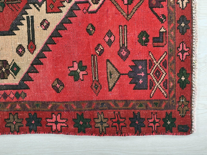 a red rug with a design on it