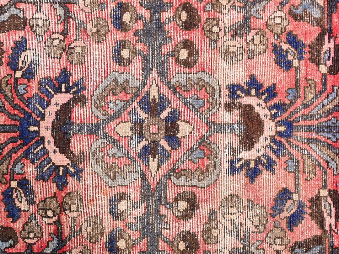 a pink rug with a blue and brown design on it