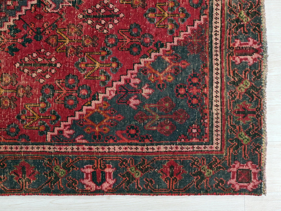 a red and green rug on a wooden floor