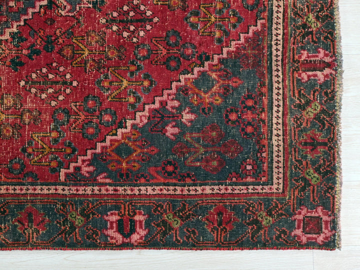 a red and green rug on a wooden floor