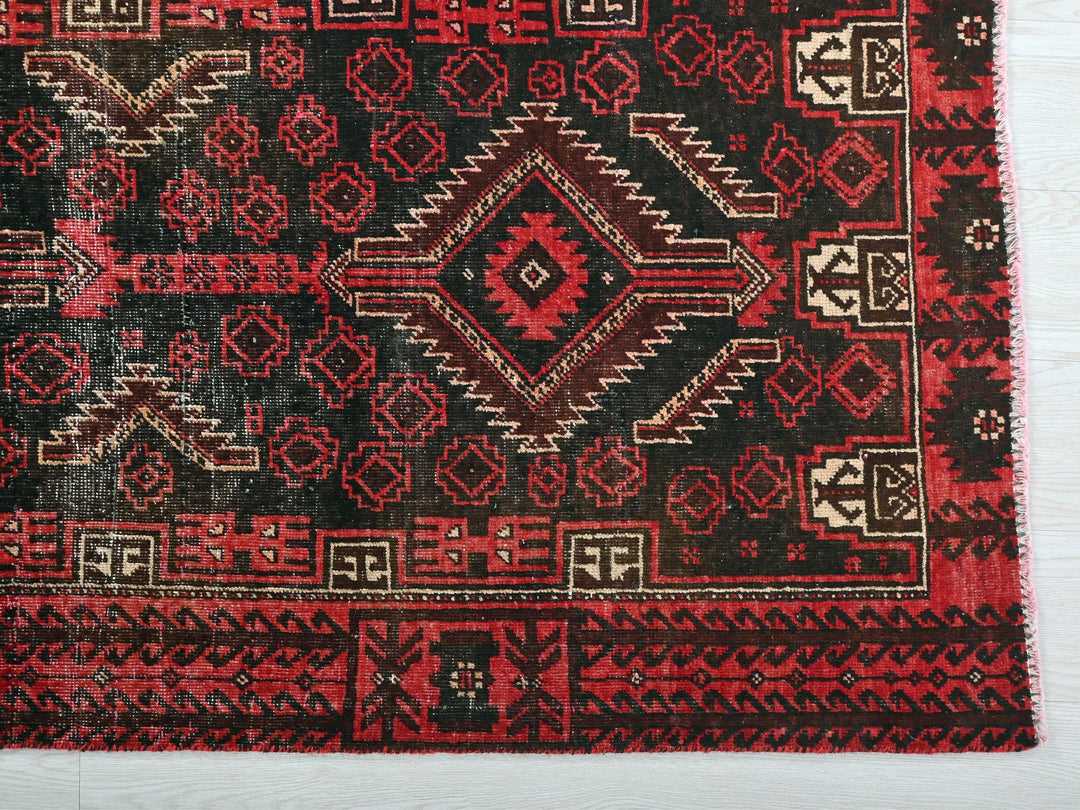 a red and black rug on a white surface