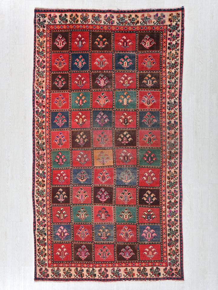 a red, blue, green, and brown rug on a white wall