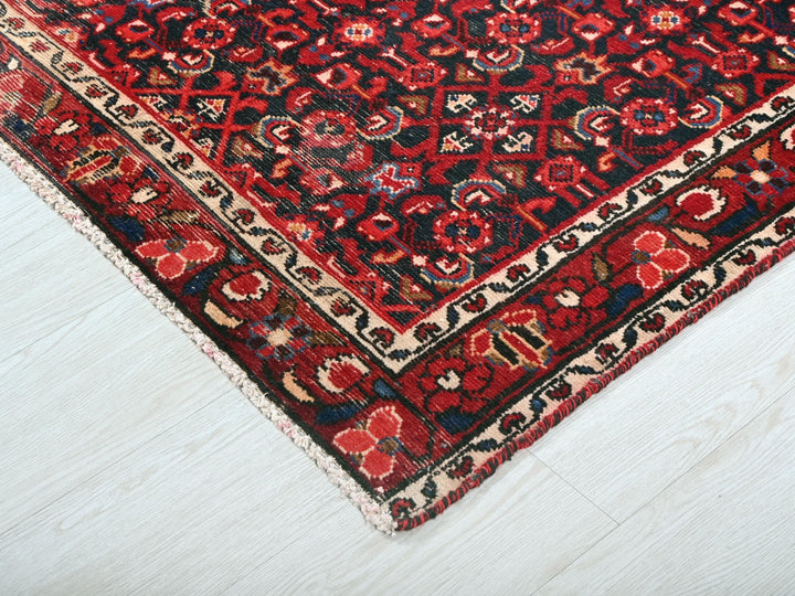 a red and black oriental rug on a white floor