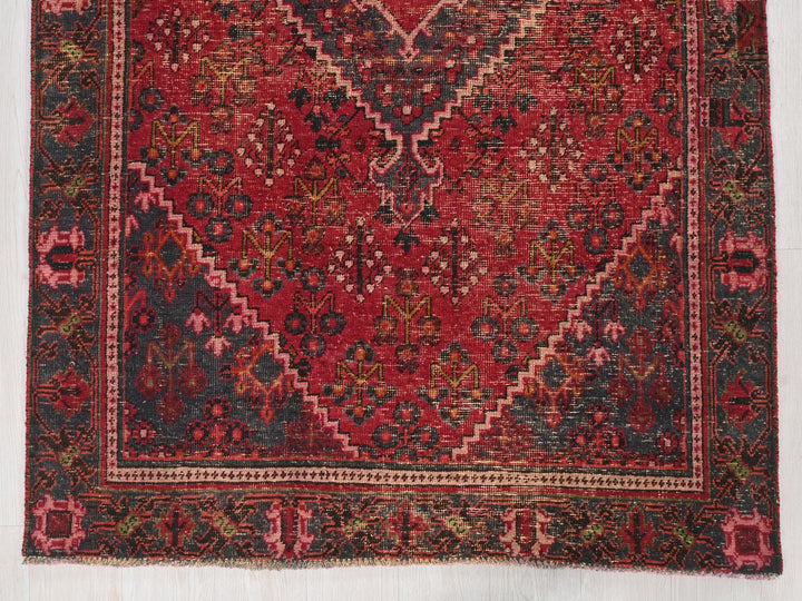 a red rug with a diamond pattern on it