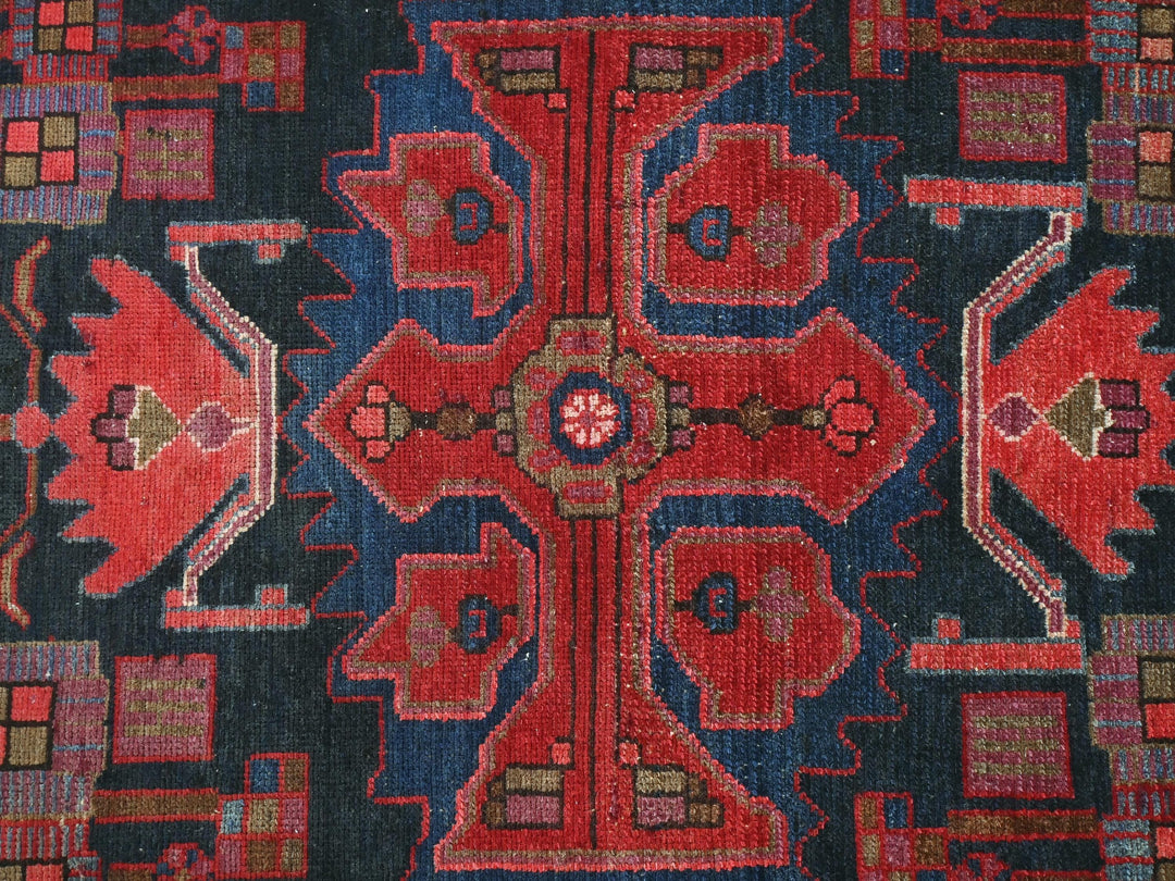 a red, blue, and black rug with a design on it