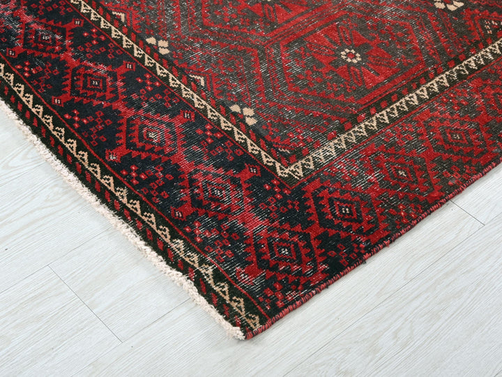 a red and black rug on a white floor
