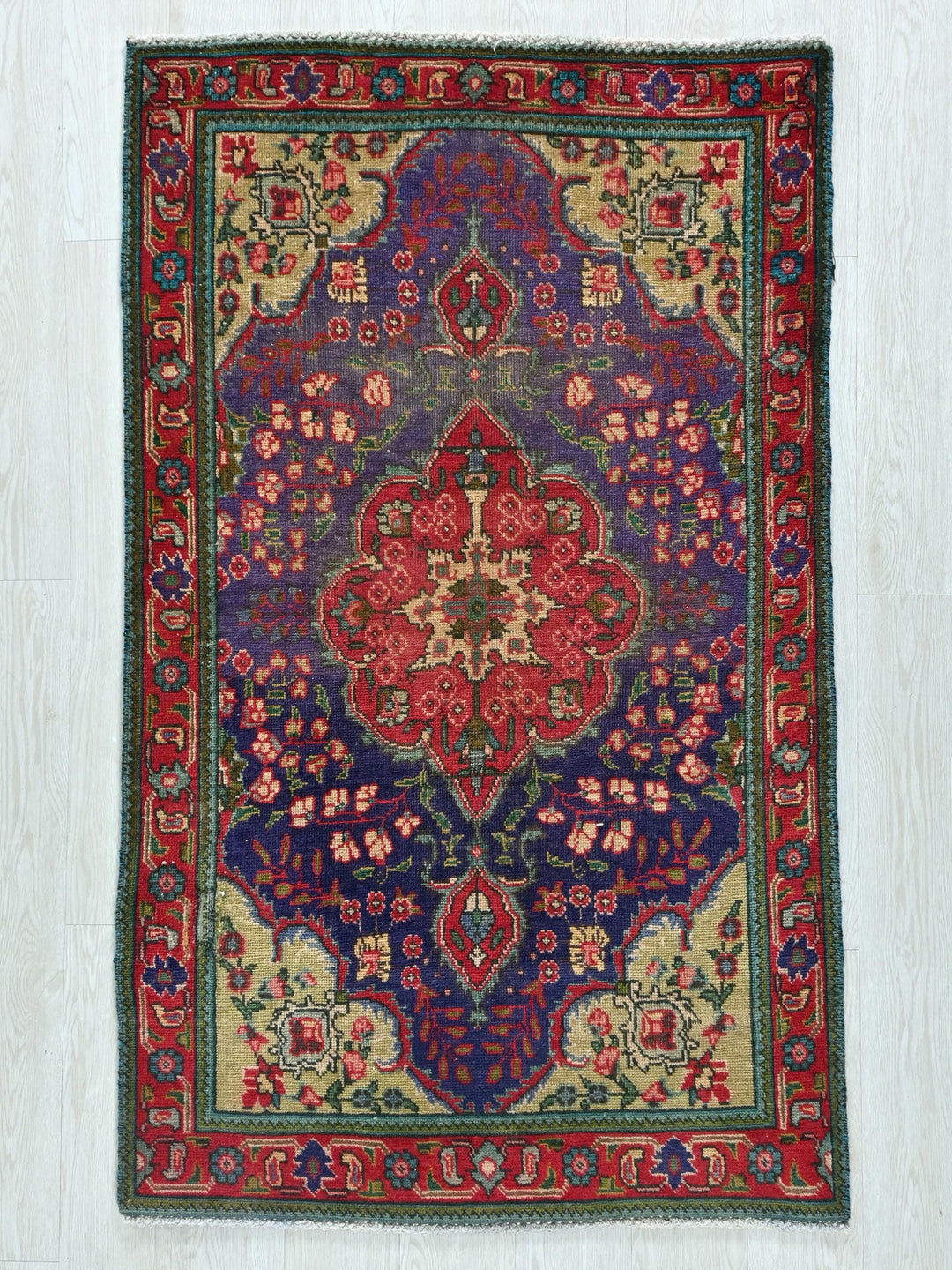 a red and blue rug on a white floor