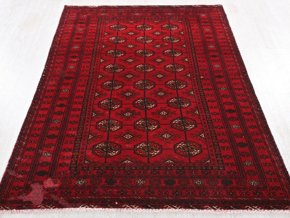 a red oriental rug on a white floor