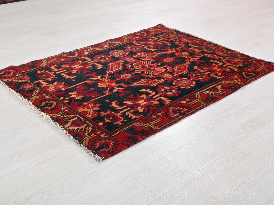 a red and black rug sitting on top of a white floor