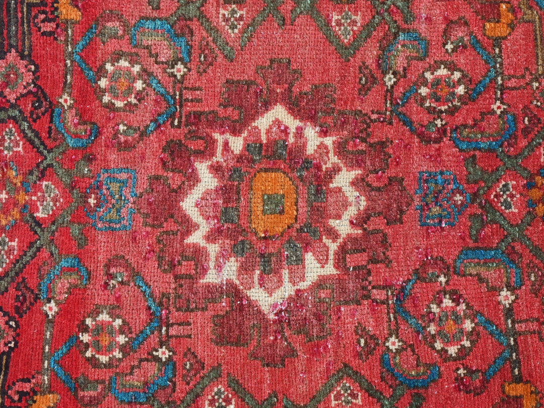 a red rug with a colorful design on it