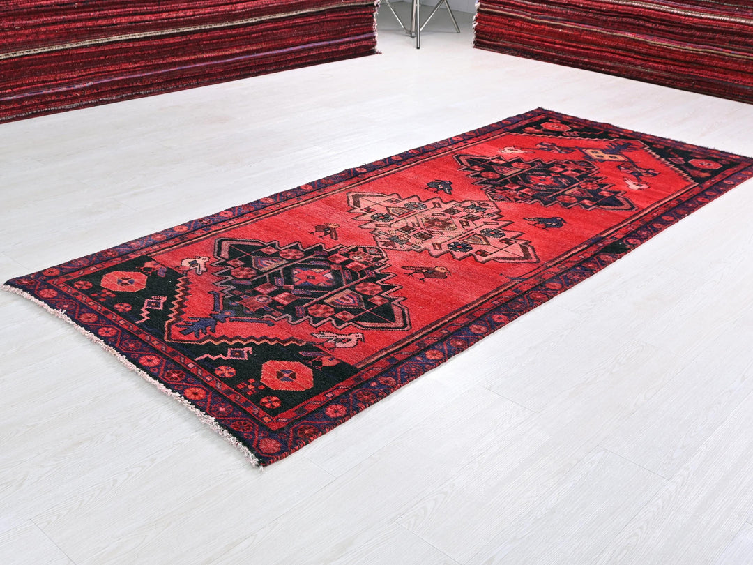 a red oriental rug on a white floor
