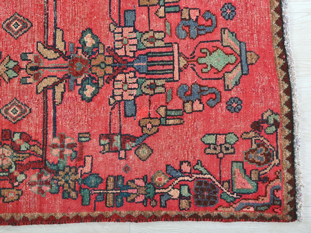 a red rug with a floral design on it