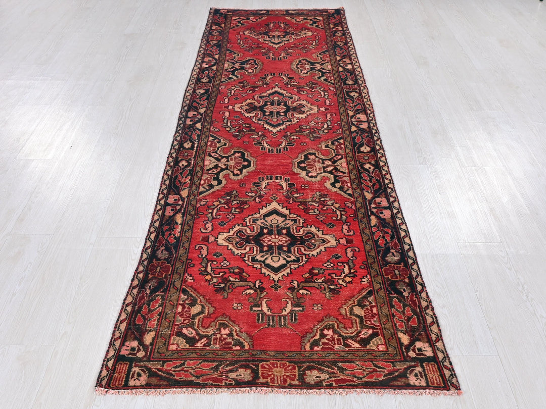 a long red rug on a white floor