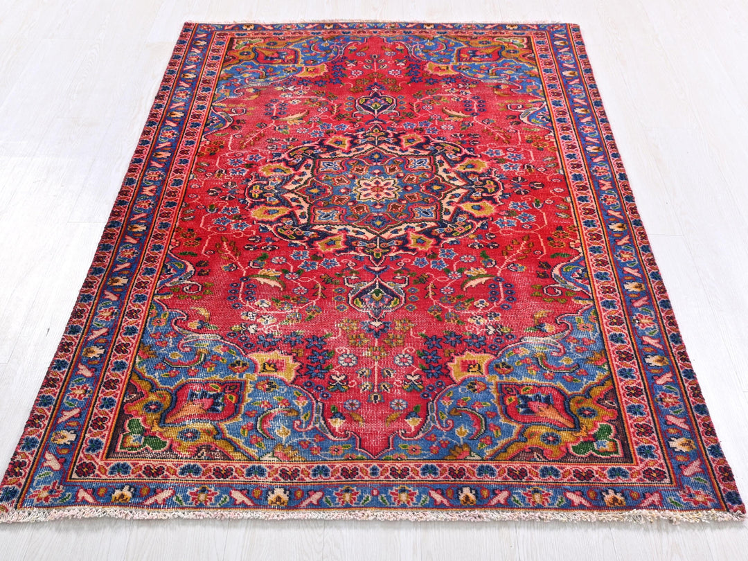 a red rug with an intricate design on a white floor
