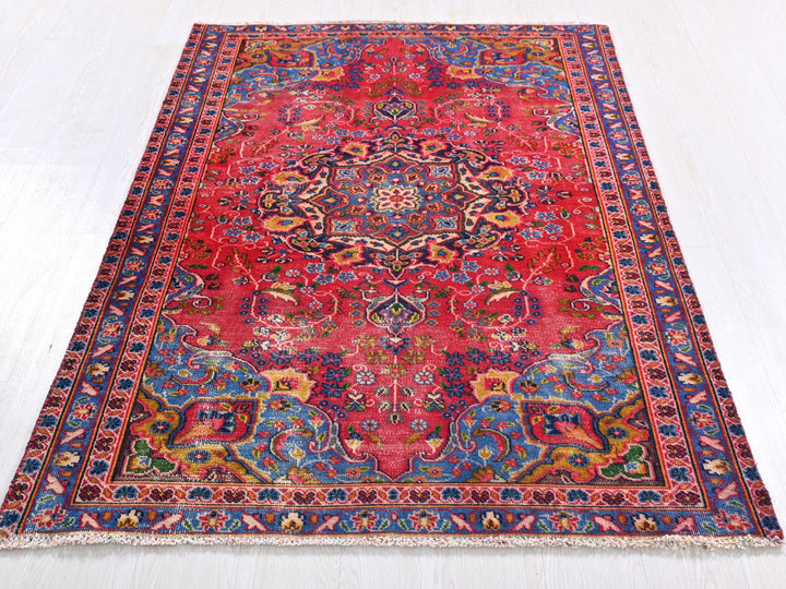 a red rug with an intricate design on a white floor
