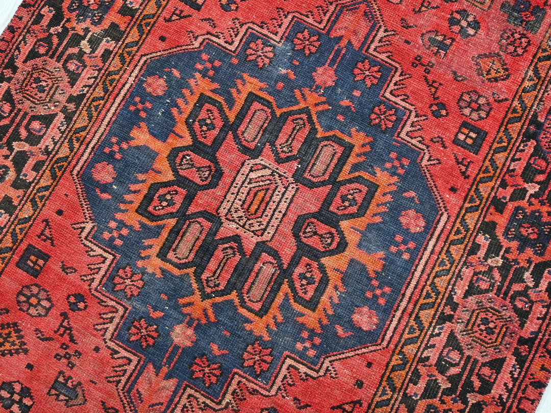 a red rug with a blue and orange design on it