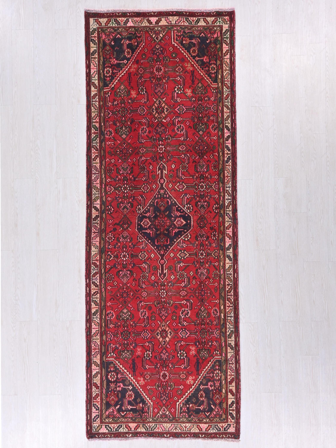 a red oriental rug hanging on a wall
