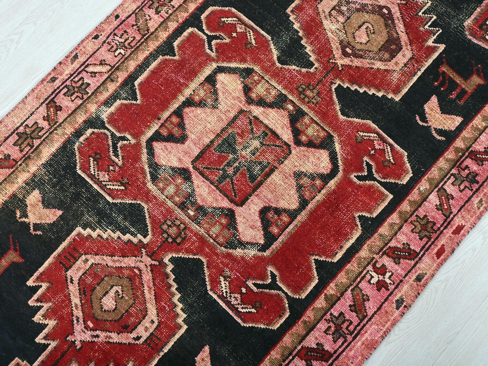 a red and black oriental rug on a white floor