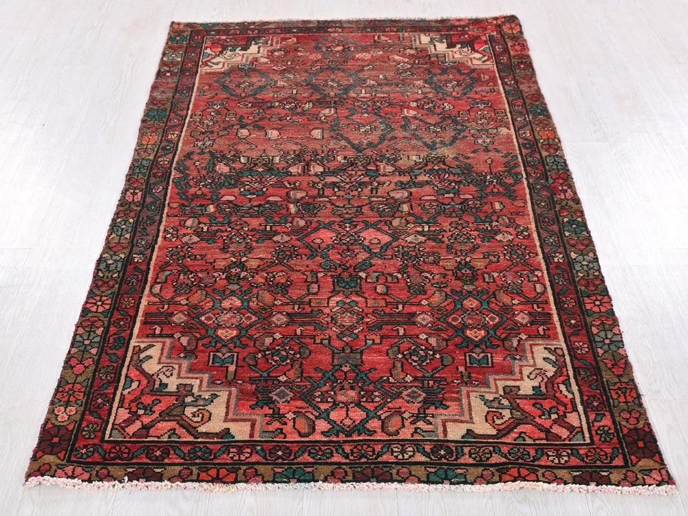 a red rug with a black border on a white floor