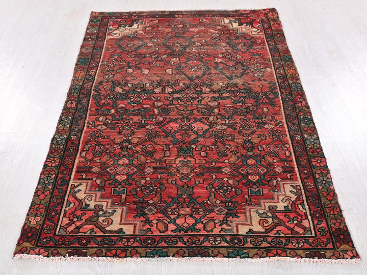 a red rug with a black border on a white floor