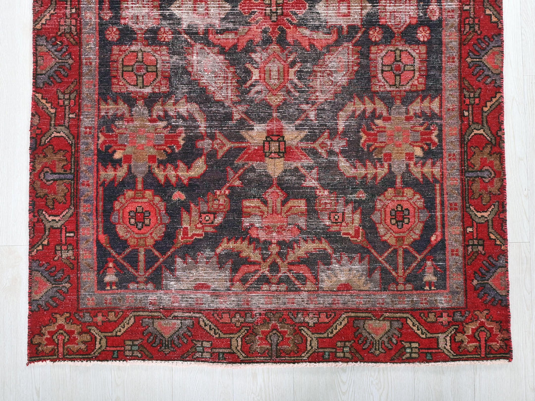 a red and black rug on a white floor
