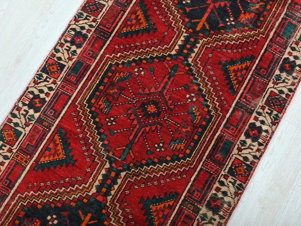 a red and black rug on a white floor
