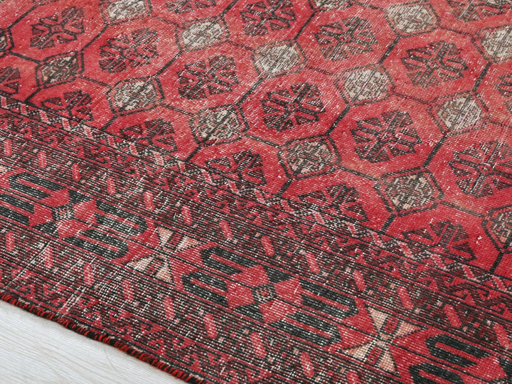 a close up of a red rug on a wooden floor