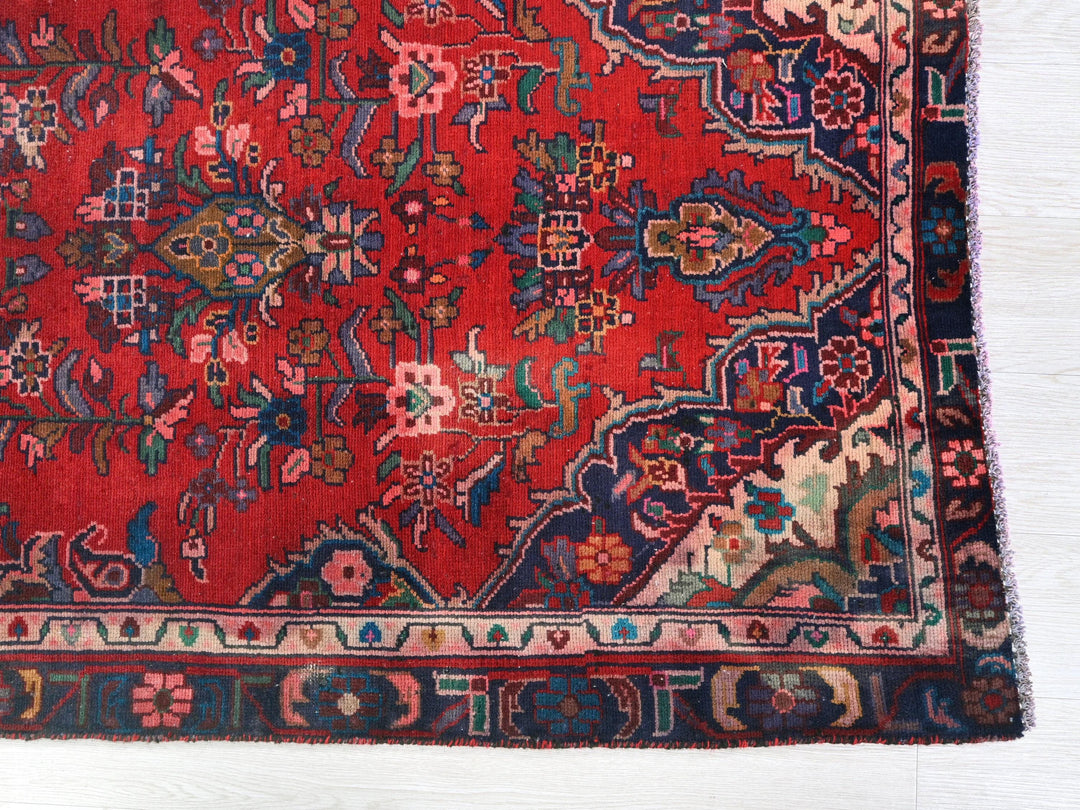 a red rug with a floral design on it