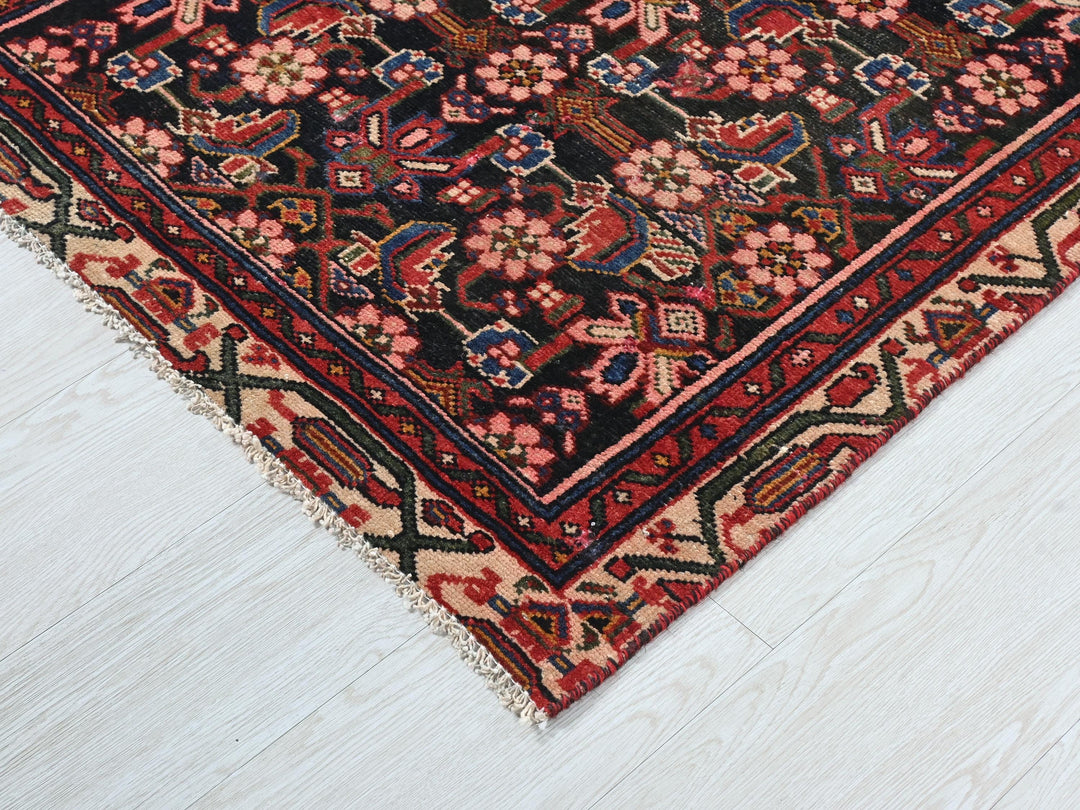 a red and black oriental rug on a white floor