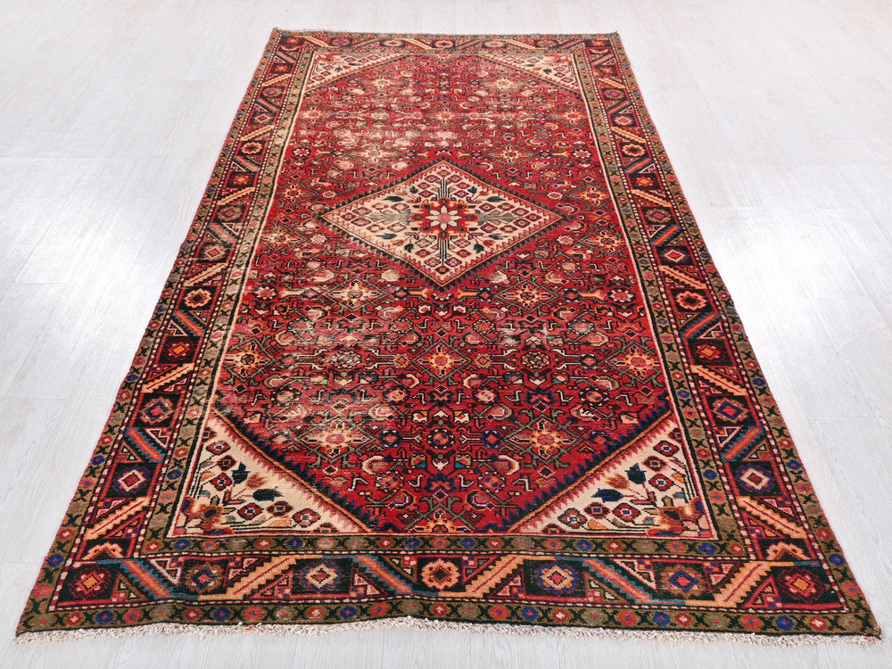 a red oriental rug on a white floor