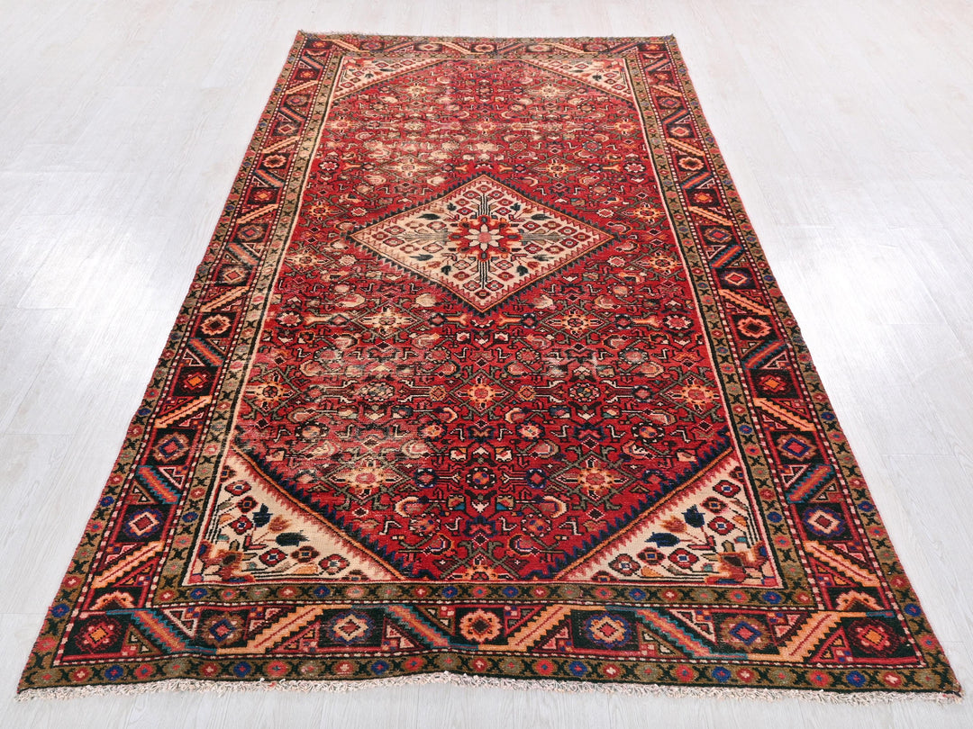 a red oriental rug on a white floor