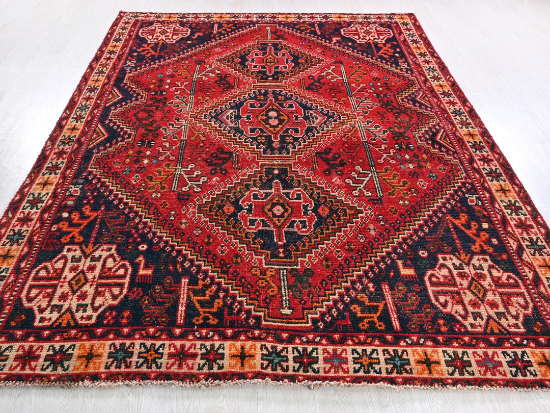 a red and blue rug on a white floor