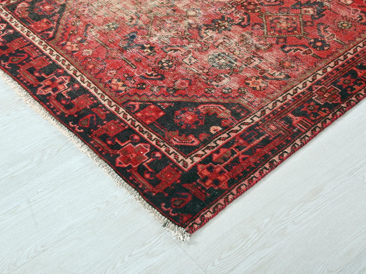 a red and black oriental rug on a white floor