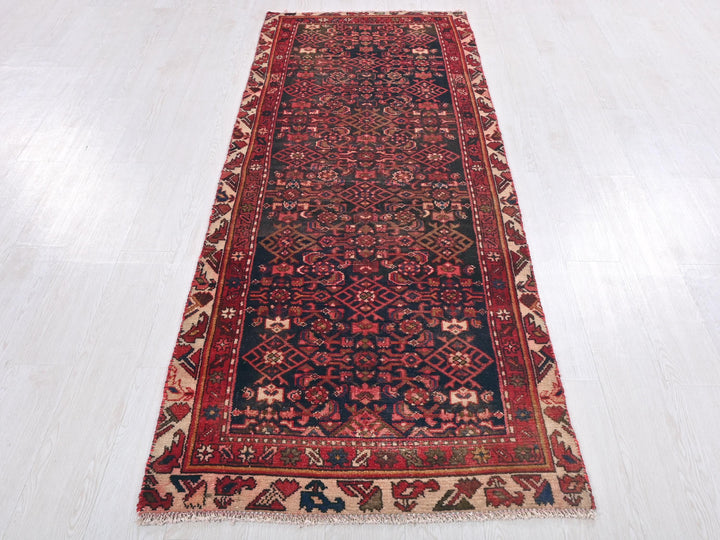 a red and black rug on a white floor