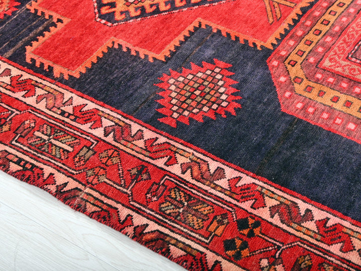 a red and blue rug on a white surface