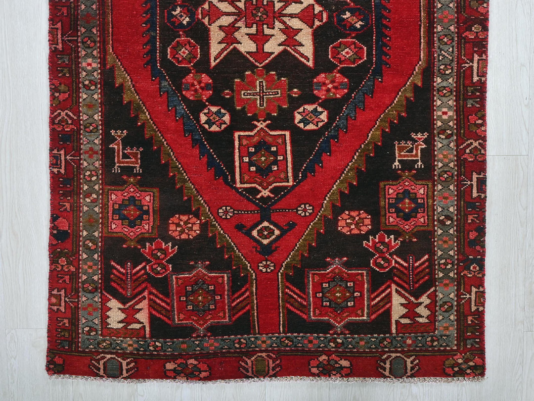 a red and black rug on a white floor