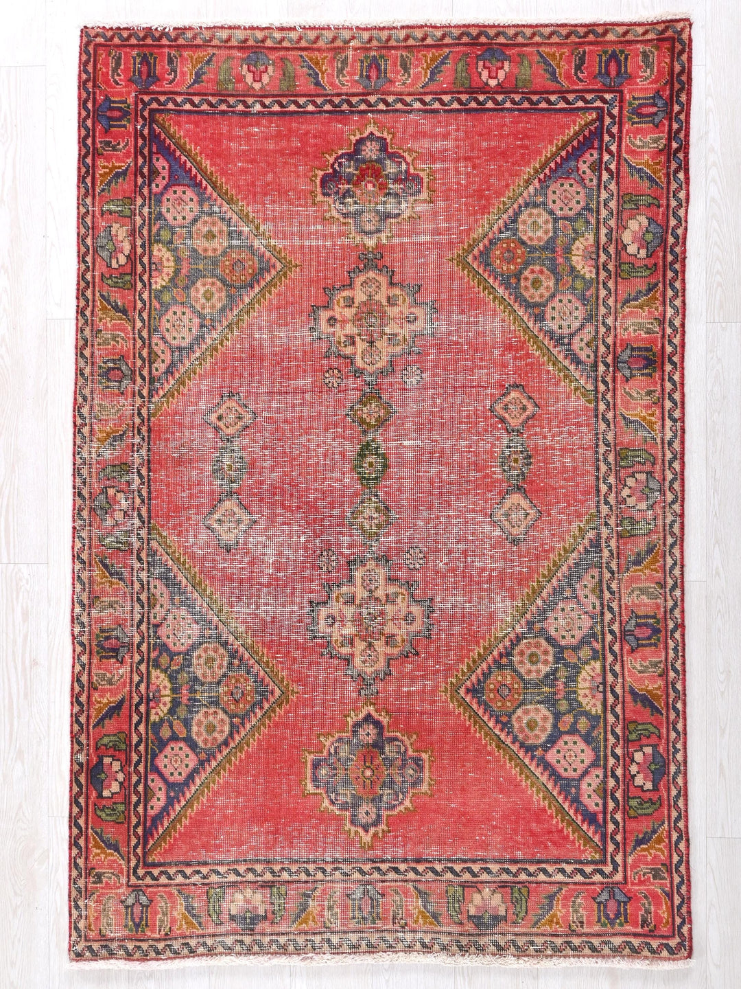 a red rug with a design on the middle of it