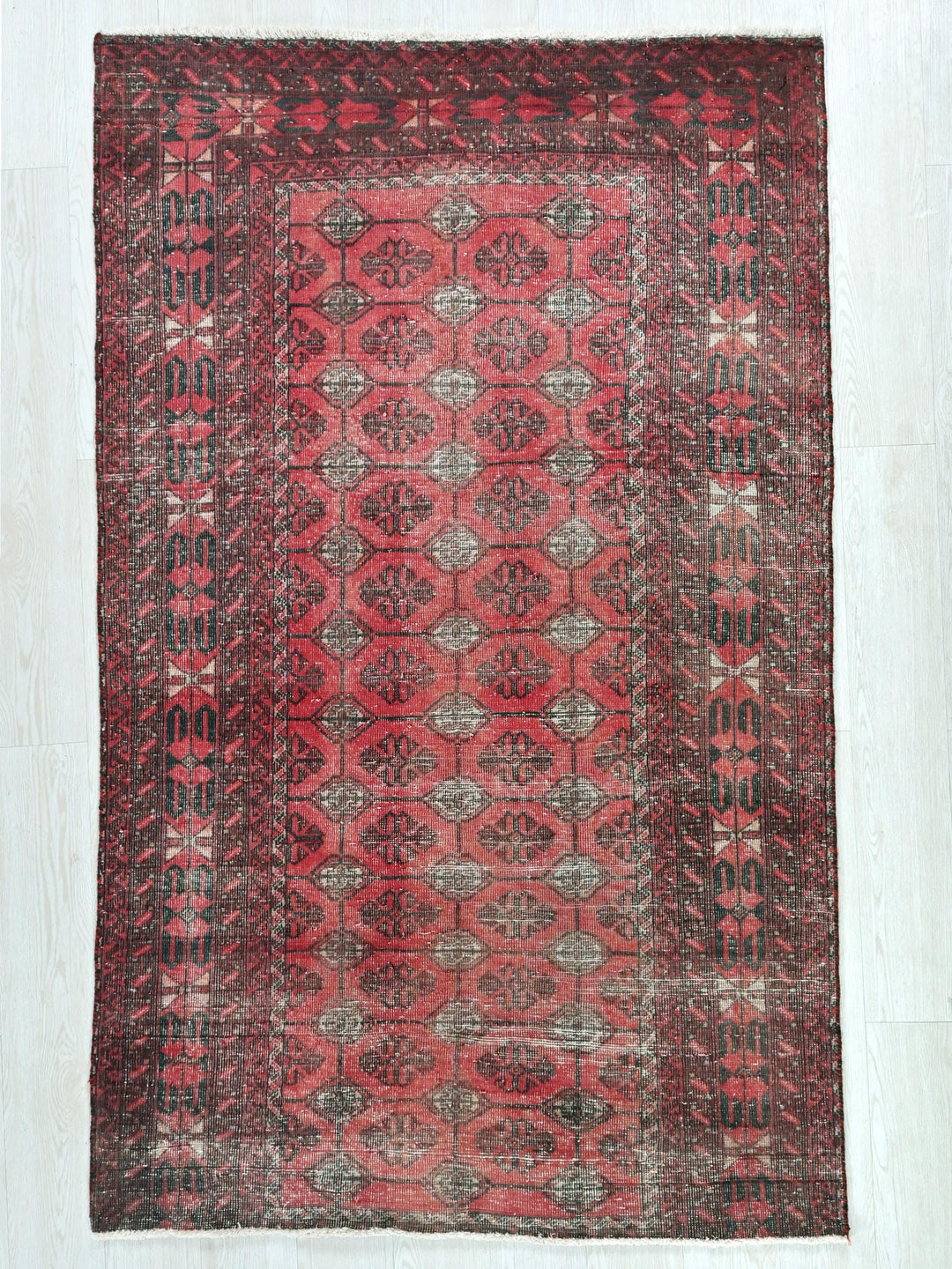 a red rug with a pattern on the middle of it